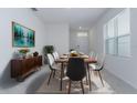 Bright dining room with modern table and chairs, neutral walls, and a large window that provides natural light at 1267 Berry Ln, Davenport, FL 33837
