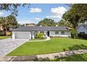 Charming exterior with lush green lawn, brick driveway, and meticulous landscaping at 1327 Bridgeport Dr, Winter Park, FL 32789