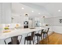 Bright modern kitchen features white cabinets, hardwood floors, stainless steel appliances, and barstool seating at 1327 Bridgeport Dr, Winter Park, FL 32789