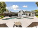 Beautiful backyard oasis with a sparkling pool, brick patio, and poolside seating at 1327 Bridgeport Dr, Winter Park, FL 32789