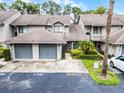 Inviting townhouse featuring attached garage, mature landscaping, and guest parking at 179 Crown Point Cir, Longwood, FL 32779