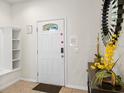Welcoming foyer featuring a decorative mirror, tile flooring, and a bright white front door at 1943 Majorca Dr, Kissimmee, FL 34747