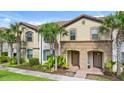Townhouse with covered entryway, complemented by lush landscaping and exterior architectural details at 1943 Majorca Dr, Kissimmee, FL 34747