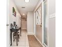 Inviting hallway with neutral tones, tile flooring, and a decorative table with a mirror at 1962 English Dr, Deltona, FL 32738