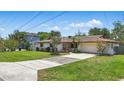 Home exterior with a lush green lawn, palm trees, and a long driveway at 2028 Lake Christie Dr, Orlando, FL 32809