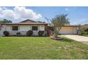 Charming home with a well-manicured lawn, stone accents, and a two-car garage at 2028 Lake Christie Dr, Orlando, FL 32809