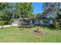 Inviting single-story home featuring a green lawn, mature trees, and attached two-car garage at 216 San Fernando Ct, Sanford, FL 32773