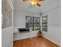 Bright bedroom featuring hardwood floors, ceiling fan, built-in desk, and sunny window at 2227 Doulton Dr, Orlando, FL 32812