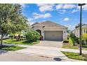 Charming home featuring a well-maintained lawn, a brick driveway, and an attached two-car garage at 2233 Antilles Club Dr, Kissimmee, FL 34747