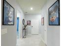 Bright hallway featuring Disney decor, tile flooring, a console table, and a white front door at 271 Jetty Way, Davenport, FL 33897