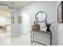 Inviting hallway with tile floors, console table, and Disney art, providing access to various rooms at 271 Jetty Way, Davenport, FL 33897