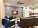 Cozy living room with stylish decor, a modern ceiling fan, and a mounted TV above an entertainment console at 271 Jetty Way, Davenport, FL 33897