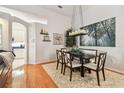 Inviting dining area featuring hardwood floors, modern chandelier, and easy access to kitchen at 404 Sotheby Way, Debary, FL 32713