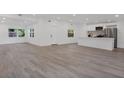 Bright, open-concept living area with wood-look floors, connecting seamlessly to the modern white kitchen at 4201 Mizell St, Orlando, FL 32812