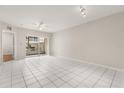 Bright living room with tile floors, fan, and sliding door access to the screened lanai at 527 Villa Del Sol Cir # 104, Orlando, FL 32824