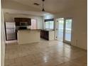 Open kitchen area with stainless steel refrigerator, granite countertops, and a view to the patio at 5918 Stratton Ln, Orlando, FL 32808