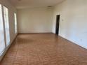Spacious living room with tile floors and natural light streaming through large windows with blinds at 5918 Stratton Ln, Orlando, FL 32808