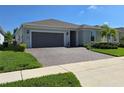 Beautiful home exterior boasting a brick driveway, lush landscaping, and a two-car garage at 6129 Citrus Grove Ct, St Cloud, FL 34771