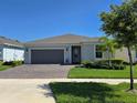 Attractive home featuring a brick driveway, manicured lawn, and a neatly maintained exterior at 6129 Citrus Grove Ct, St Cloud, FL 34771