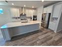 Modern kitchen with white cabinets, quartz countertops, stainless steel appliances, and a large island at 6129 Citrus Grove Ct, St Cloud, FL 34771
