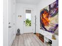 Bright foyer featuring a decorative painting, sleek wood floors, and ample natural light at 652 Benoi Dr, Davenport, FL 33896