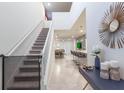 Open entryway with a staircase and views of the dining room, living room, and kitchen with a large island at 7352 Oakmoss Loop, Davenport, FL 33837