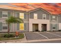 Charming two-story townhouse with gray siding, green shutters, and assigned parking at 7577 Oak Spring Ln, Davenport, FL 33837