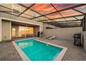 Backyard pool with patio seating, grill, and lush landscaping at 7577 Oak Spring Ln, Davenport, FL 33837