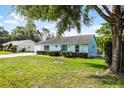 Charming light blue one-story home with a well-manicured front yard and lovely landscaping at 8121 Via Bonita, Sanford, FL 32771