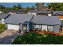Charming single-Gathering home featuring a grey roof, stone accents, and well-manicured lawn at 838 Haulover Dr, Altamonte Springs, FL 32714