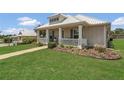 A quaint home with well-kept lawn and landscaping, as well as a covered porch ideal for relaxing and enjoying the outdoors at 106 Turtle Run, Umatilla, FL 32784