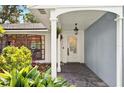 Inviting front porch featuring slate flooring, a hanging lantern and lush landscaping at 1202 Marshall Ct, Eustis, FL 32726