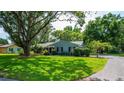 Charming single-story home with a beautifully landscaped front yard and mature trees at 1202 Marshall Ct, Eustis, FL 32726