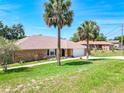 Lovely brick house with a manicured front yard and mature palm trees providing curb appeal at 1233 Gladstone Dr, Deltona, FL 32725