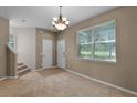 Comfortable living room with staircase and neutral color palette, bathed in natural light from the window at 12335 Cruxbury Dr, Windermere, FL 34786