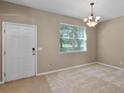 Inviting living area featuring neutral tones, plush carpet, and a bright window offering natural light at 12335 Cruxbury Dr, Windermere, FL 34786