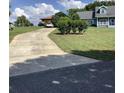 Long driveway leading to a well-maintained blue home with lush landscaping at 13111 Sunshine Cir, Clermont, FL 34711