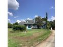 Attractive blue home with dormers, a welcoming front porch, and a nicely landscaped yard at 13111 Sunshine Cir, Clermont, FL 34711