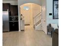 Open entryway with tile flooring, featuring stairs with white railing, and access to the kitchen and living areas at 16391 Admirals Cove Ln, Winter Garden, FL 34787