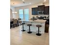 Contemporary kitchen featuring a center island with bar stool seating, black cabinets, and stainless appliances with natural light at 16391 Admirals Cove Ln, Winter Garden, FL 34787