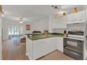 Open kitchen with white cabinets, stainless steel appliances, and natural light from the adjacent living area at 1642 Windsor Oak Ct, Kissimmee, FL 34744