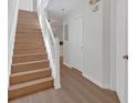 Bright entryway with wooden staircase and sleek, light-colored, modern hardwood flooring at 1642 Windsor Oak Ct, Kissimmee, FL 34744