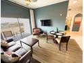 Inviting living room with a comfy leather sofa, a flat-screen TV, balcony with chairs, and adjacent to a dining area at 225 Celebration Pl # 527, Kissimmee, FL 34747