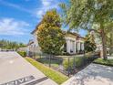 Beautiful home featuring manicured landscaping, wrought iron fence and a paver driveway at 242 W Lyman Ave, Winter Park, FL 32789