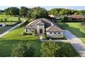 Expansive home showcasing its beautiful landscaping, stone accents, paver driveway, and tiled roof at 25859 Crossings Bluff Ln, Sorrento, FL 32776