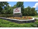 Red Tail community sign surrounded by colorful flowers and lush greenery at 25859 Crossings Bluff Ln, Sorrento, FL 32776