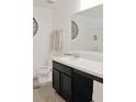 Well-lit bathroom featuring a dark vanity with white countertop and a large mirror at 2835 Mosshire Cir, St Cloud, FL 34772