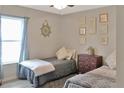 Cozy bedroom with two twin beds, a window, and nautical-themed decor for a relaxing atmosphere at 2835 Mosshire Cir, St Cloud, FL 34772