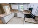 Bright kitchen featuring white cabinetry, stainless steel appliances, and tile countertops at 2928 Ne 14Th Ave, Ocala, FL 34479