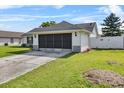 Rear view of home showing the screened garage, manicured lawn and privacy fence at 2966 Derby Dr, Deltona, FL 32738